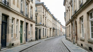 Façades anciennes en pierre du centre de Rennes bordant une rue pavée, photographiées dans une ambiance réaliste de reportage immobilier.